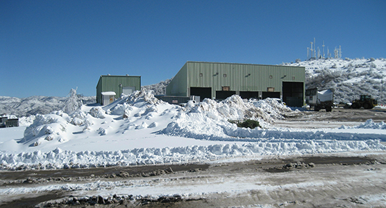 Recycling center with snow in the foreground.