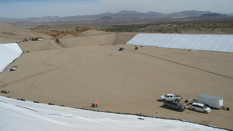 A construction within workers prepping a large area of dirt.