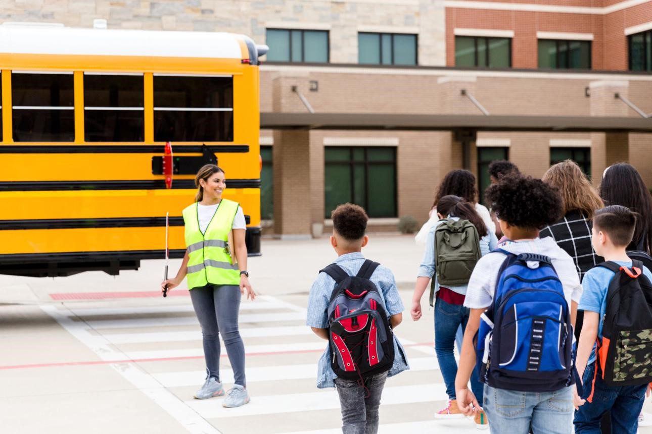 Children crossing the street with the help of a crossguard,